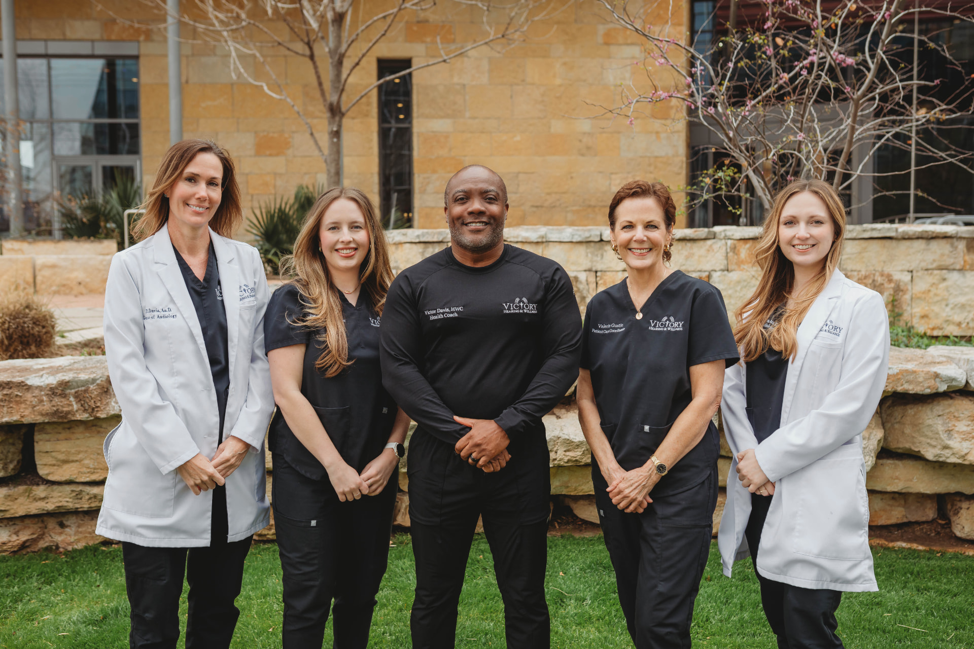 The Victory Health & Wellness clinical and coaching team — Dr. Jill Davis, Isabella Garza, Victor Davis, Valerie Gustin, and Dr. Monica Trevino — standing together outdoors in front of the clinic
